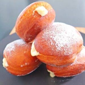 doughnut with filling pouring ou stacked over black plate