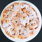 Fluffy homemade apple cinnamon bread rolls arranged in a round serving dish.