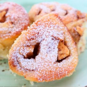 Fluffy homemade apple cinnamon bread rolls arranged in a green serving plate.