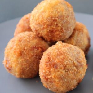 risotto balls stacked on black plate