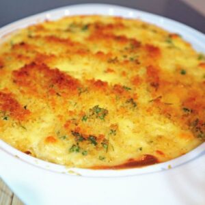 Creamy baked mac and cheese with golden breadcrumb topping in a dish