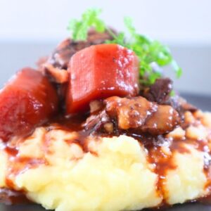 French beef stew Boeuf Bourguignon with carrots, mushrooms, and pearl onions served potato mash.