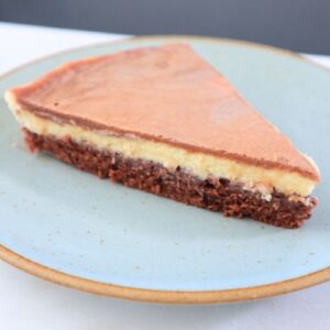 A slice of Chantilly and chocolate cake with whipped cream topping and chocolate ganache.