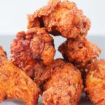 Crispy homemade fried chicken staked on white plate