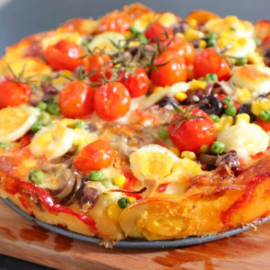 Portuguese savoury pie with cherry tomatoes on a round tray over chopping block