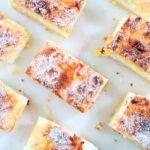 Lemon yogurt slice cut into squares with powdered sugar on top